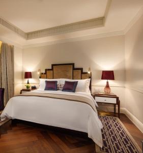 上海市にあるJinjiang Metropolo Hotel Classiq,Shanghai Bund Circleのベッドルーム(大きな白いベッド1台、ランプ2つ付)