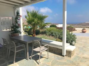 a table and chairs on a patio with a view of the ocean at Yakinthos Suites in Mykonos