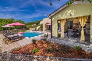 a home with a pool and a patio with a table and chairs at Holiday house MARLY with private pool in Kras