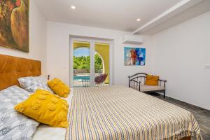 a bedroom with a bed and a couch and a window at Holiday house MARLY with private pool in Kras +29 photos
