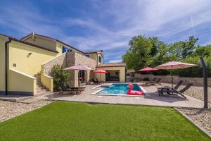 a pool with a person in a red swimsuit in a backyard at Holiday house MARLY with private pool in Kras