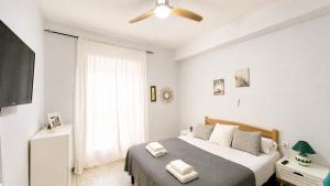 a bedroom with a bed with two towels on it at APARTAMENTO SOL Y PLAYA in Santa Pola