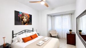 a bedroom with a large white bed with orange pillows at APARTAMENTO SOL Y PLAYA in Santa Pola