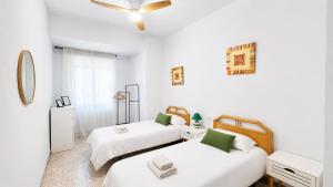 two beds in a room with white walls at APARTAMENTO SOL Y PLAYA in Santa Pola