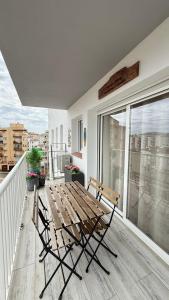 a wooden table and chairs on a balcony at Sunrisemare Vacational Studio in Roses