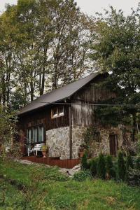 a small log cabin with a black roof at ojcowska stodoła in Wola Kalinowska