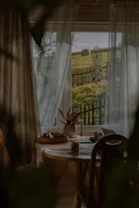 a room with a table and a window with a view of a field at ojcowska stodoła in Wola Kalinowska +13 photos