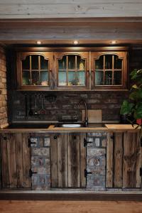 a kitchen with wooden cabinets and a sink at ojcowska stodoła in Wola Kalinowska