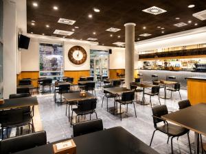 a restaurant with tables and chairs and a clock on the wall at Hotel Andia in Orcoyen