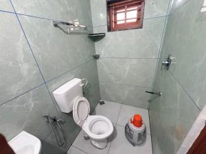 a small bathroom with a toilet and a shower at Zensta Residency in Cochin +5 photos