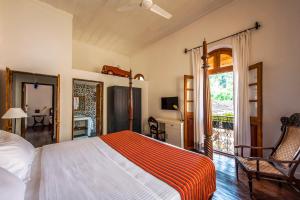 a bedroom with a bed and a room with a window at Mateus Boutique Hotel in Panaji