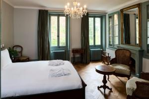a bedroom with a bed and a chandelier at Auberge aux 4 Vents in Fribourg