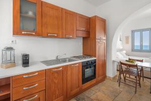 a kitchen with wooden cabinets and a sink and a table at Sea view rooms in kardiani by TinosStay in Kardhianí +118 photos