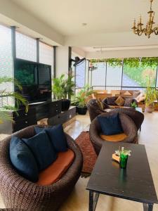 a living room with wicker chairs and a table at Zamin Suites in Abuja