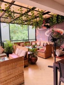 a room with wicker chairs and tables and plants at Zamin Suites in Abuja