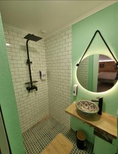 a bathroom with a round mirror and a sink at Wonder Charm in Albufeira