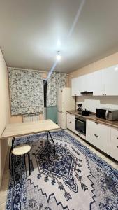 a kitchen with a table and a rug at Daraboz in Almaty