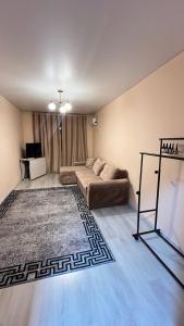 a living room with a couch and a rug at Daraboz in Almaty
