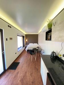 a bedroom with a bed and a kitchen with a table at Cabaña San Pedro 2 in Concepción