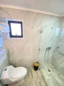 a bathroom with a white toilet and a shower at Cabaña San Pedro 2 in Concepción