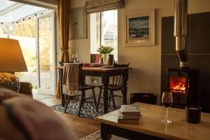 a living room with a table and a wood stove at Blacksheep Cottage in Oban +19 photos