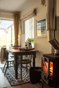 a kitchen with a table and a wood stove at Blacksheep Cottage in Oban