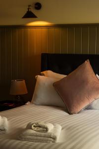 a bed with towels and pillows on top of it at Blacksheep Cottage in Oban