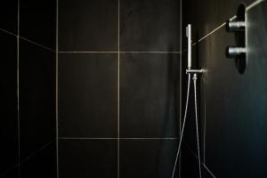 a shower in a bathroom with a tile wall at Blacksheep Cottage in Oban