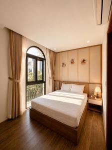 a bedroom with a large bed and a window at SOLÉRA 2 Homestay in Phú Quốc
