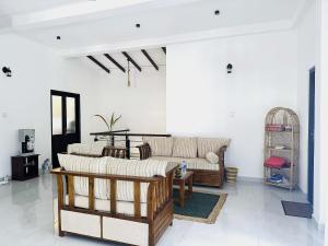 a living room with two couches and a table at Slow Life Coliving, Hiriketiya in Dickwella