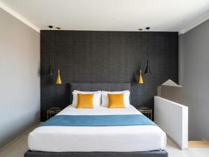 a bedroom with a large bed with yellow pillows at Suite Apollinare in Ravenna