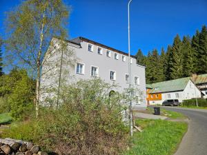 a white building on the side of a road at Apartmán Jizerské údolí in Kořenov