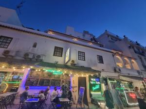 a group of people sitting at tables outside of a building at Wonder Charm in Albufeira