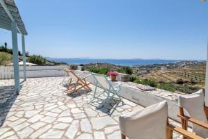 a group of chairs sitting on a stone patio at Αστραία - με θέα στο Αιγαίο in Agios Ioannis