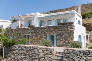a house on top of a stone wall at Αστραία - με θέα στο Αιγαίο in Agios Ioannis