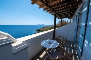 a table and chairs on a balcony overlooking the ocean at Sea view rooms in kardiani by TinosStay in Kardhianí