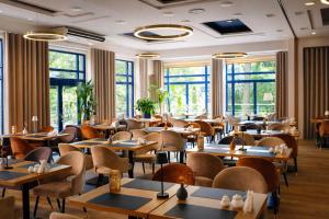 a restaurant with tables and chairs and windows at Hotel Kudowa Manufaktura Relaksu in Kudowa-Zdrój +74 photos