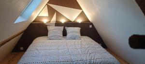 a small bedroom with a bed with two pillows at Gîte Escapade À La Voreille in Mazirat