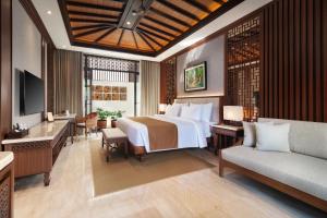a hotel room with a bed and a couch at MĀUA OLEA Ubud by Swiss-Belhotel in Ubud