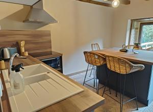 a kitchen with a sink and a counter at Gîte Escapade À La Voreille in Mazirat