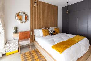 a bedroom with a large bed with a yellow blanket at Nova, Sky Suites in Accra +111 photos