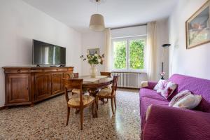 a living room with a table and a purple couch at CASA CARLINA Pet Friendly in Salò