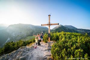 a group of people standing next to a cross on a mountain at Pension Südhang in Bad Kleinkirchheim