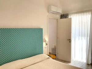 a bedroom with a bed and a green wall at Mana House in Maiori