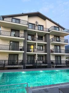 an apartment building with a swimming pool in front of it at Fethiye Serenity Suites in Fethiye