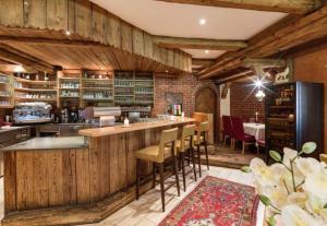 a kitchen with wooden walls and a bar with stools at Sidan Hotel Restaurant & Pizzeria in Schwendau
