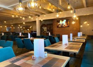 a restaurant with wooden tables and blue chairs at Sidan Hotel Restaurant & Pizzeria in Schwendau +15 photos