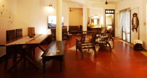 a living room with a dining table and chairs at Panackal Heritage Home in Trivandrum