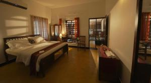 a bedroom with a bed and a chair in it at Panackal Heritage Home in Trivandrum