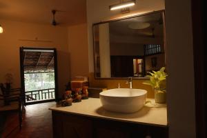 a bathroom with a sink and a large mirror at Panackal Heritage Home in Trivandrum +17 photos